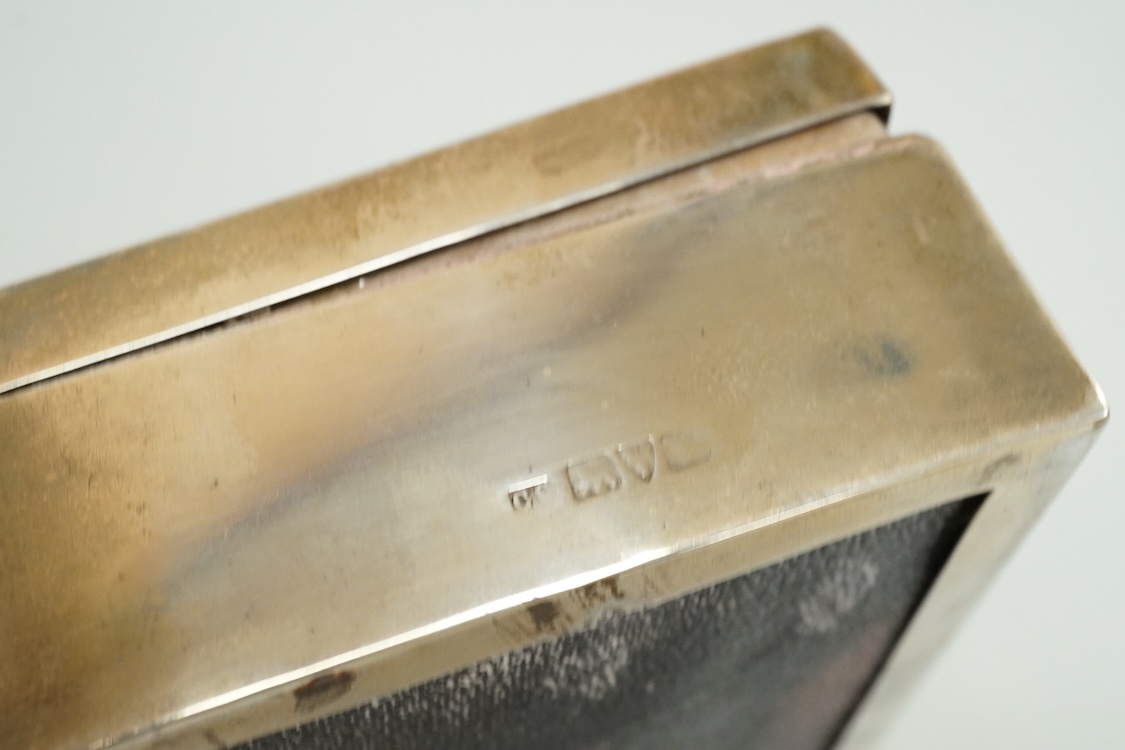 An engine turned silver rectangular cigarette box, 14.1cm and two mid 20th century engine turned silver cigarette cases.